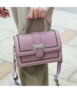 Close-up of lilac crossbody bag with H-buckle and patterned woven shoulder strap