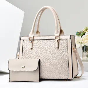 Dettaglio del set di borse in ecopelle beige con goffratura testurizzata effetto serpente