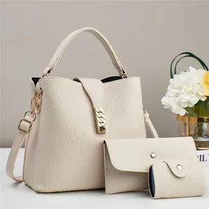 Detailed macro of cream faux leather handbag set with lychee grain and gold hardware