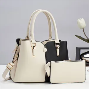 Detail view of contrast color handbag set with matching pouch and gold-tone hardware