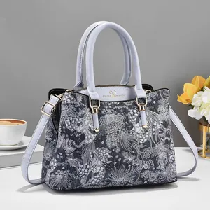 Detail van de florale jacquardstof van een tote bag met verstelbare leren riemen