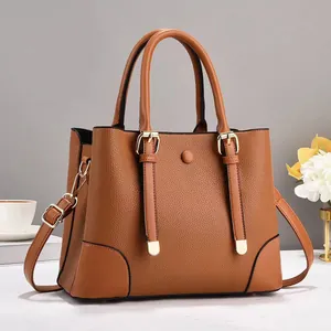 Detailed macro view of the brown lychee grain texture and gold buckle on a stylish tote