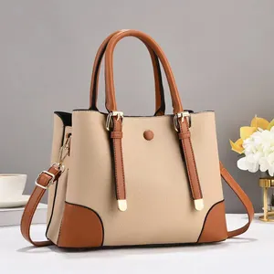 Detail of lychee textured handbag with contrast stitching and golden hardware accents