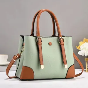 Detail of the litchi pattern leather stitching and gold hardware on the green handbag