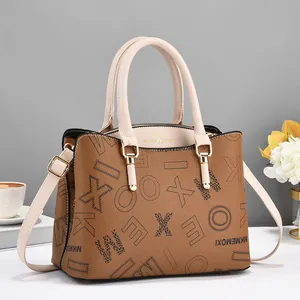 Detail of lychee pattern leather tote bag with elegant golden hardware and lettering