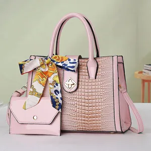 Detailed shot of pink faux crocodile leather handbag set with scarf and small clutch