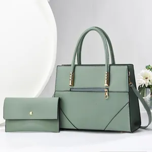 Detail view of sage green faux leather handbag set with geometric quilting and gold hardware