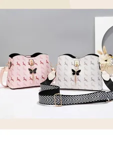Détail de sacs seaux rose et blanc avec imprimé élan, breloque nœud et sangle large