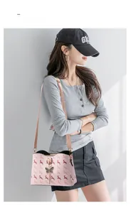 Sac seau rose avec imprimé chevaux rouges et pendentif papillon noir élégant