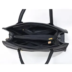 Internal structure of large black tote bag featuring multiple zippered compartments and pockets