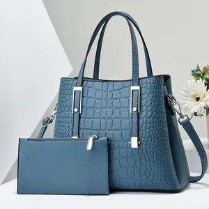 Dettaglio della borsa tote grigio-blu con stampa coccodrillo, finiture argento e tracolla