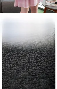 Macro close-up of premium black lychee-grain cowhide leather texture on a tote bag