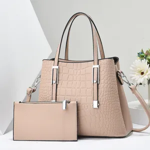 Dettaglio del set borsa tote beige con trama a coccodrillo e fibbie argentate