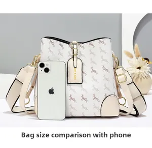 Detail view of cream bucket bag texture and deer print with smartphone for size comparison