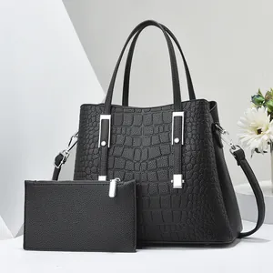 Dettaglio della borsa tote nera trama coccodrillo con pochette e finiture in metallo argento
