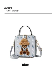 Detail view of the blue box bag featuring a bear ornament and white horse print