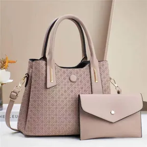 Detail of mauve embossed leather handbag set with woven texture and gold hardware