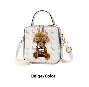 Detail of beige square handbag with deer print and 3D teddy bear ornament and gold clasp