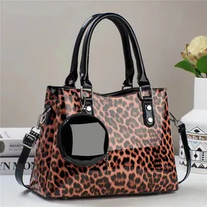 Detail of leopard print handbag with black patent leather straps and round coin purse
