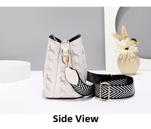 Vue latérale du sac seau beige avec motif cerf et large bandoulière à chevrons