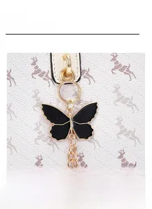 Détail du fermoir papillon doré avec chaîne sur le sac seau en cuir imprimé