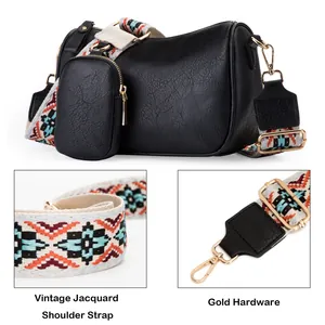 Detail of vintage jacquard strap and gold hardware on black faux leather saddle bag