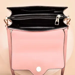 Detail view of pink crossbody bag interior with multiple compartments and gold hardware