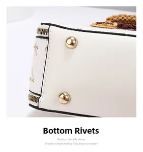 Macro shot of protective gold bottom rivets and stitching details on the leather box bag