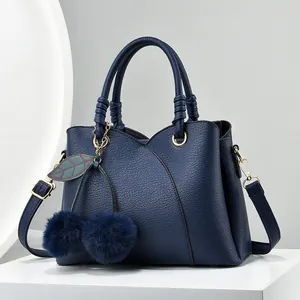 Navy blue lychee pattern leather handbag with cherry pom-pom charm and adjustable strap