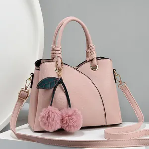 Pink lychee grain leather handbag with cherry pompom charm and braided handles