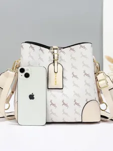 Chic beige bucket bag with deer print, gold hardware and wide strap, shown with phone