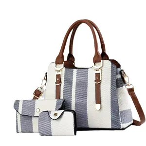 Three-piece grey striped canvas tote bag set with brown leather handles and shoulder strap