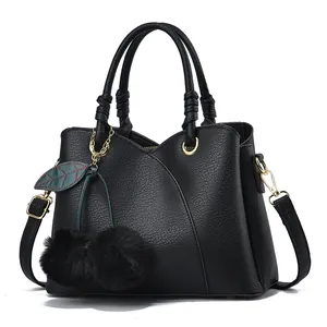 Chic black pebbled leather handbag with wave stitching and fuzzy charm decor