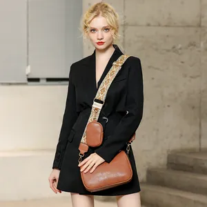 Brown saddle bag with ethnic jacquard strap and mini pouch shown on fashion model