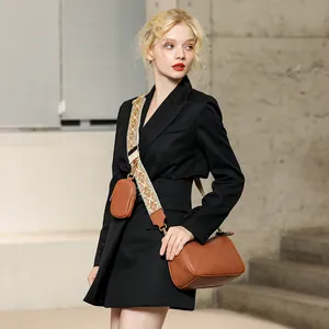 Detail of brown faux leather saddle bag with wide jacquard woven geometric strap