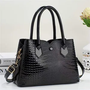 Detail of glossy octopus texture faux leather and golden hardware on black handbag