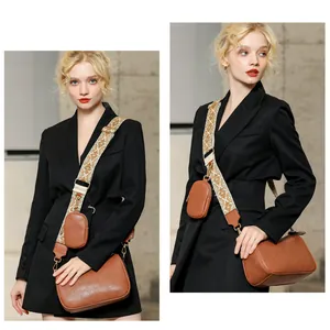 Close-up of brown textured crossbody saddle bag with a patterned wide strap and mini coin pouch