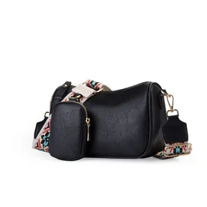 Elegant black faux leather saddle bag with geometric woven strap and small coin pouch