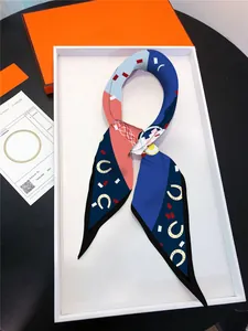 Detail of a patterned silk twilly scarf with horse motifs in a chic luxury gift box