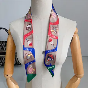 Detail of printed silk twilly scarf tied on neck model featuring colorful cartoon motifs