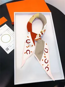 Detailed view of horse-themed twilly silk scarf presented in a luxury gift box