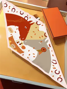 Detail of lozenge silk scarf with cartoon horse motif and orange luxury gift box