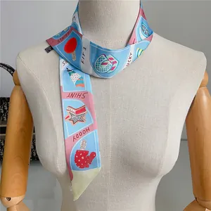 Detailed view of a colorful twilly silk scarf with star and popsicle prints on a mannequin
