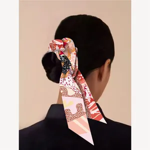 Détail d'un ruban à cheveux en soie avec motifs de fleurs et chiots sur queue de cheval