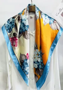 Détail d'un foulard en soie avec imprimé hortensia bleu et rose sur fond jaune