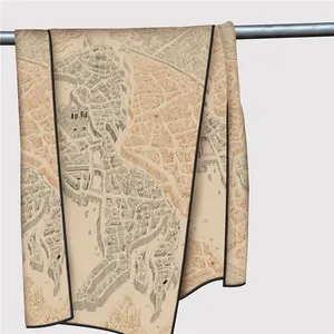 Detailed close-up of hand-rolled edges and vintage city map print on summer shawl