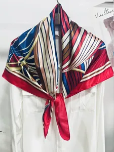 Detail of a geometric striped silk scarf tied on a white shirt collar for office styling