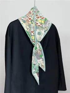 Detailmuster eines bunten Seidenschals mit Illustrationen auf einem schwarzen Blazer