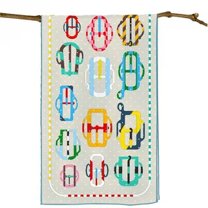 Close-up of silk scarf with horse buckle pattern and polka dots on a wooden branch