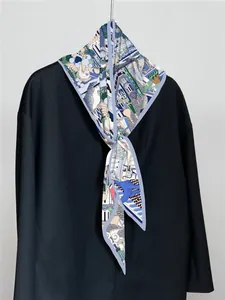 Detail eines Seidenschals mit Schloss-Illustrationen an einem schwarzen Blazer